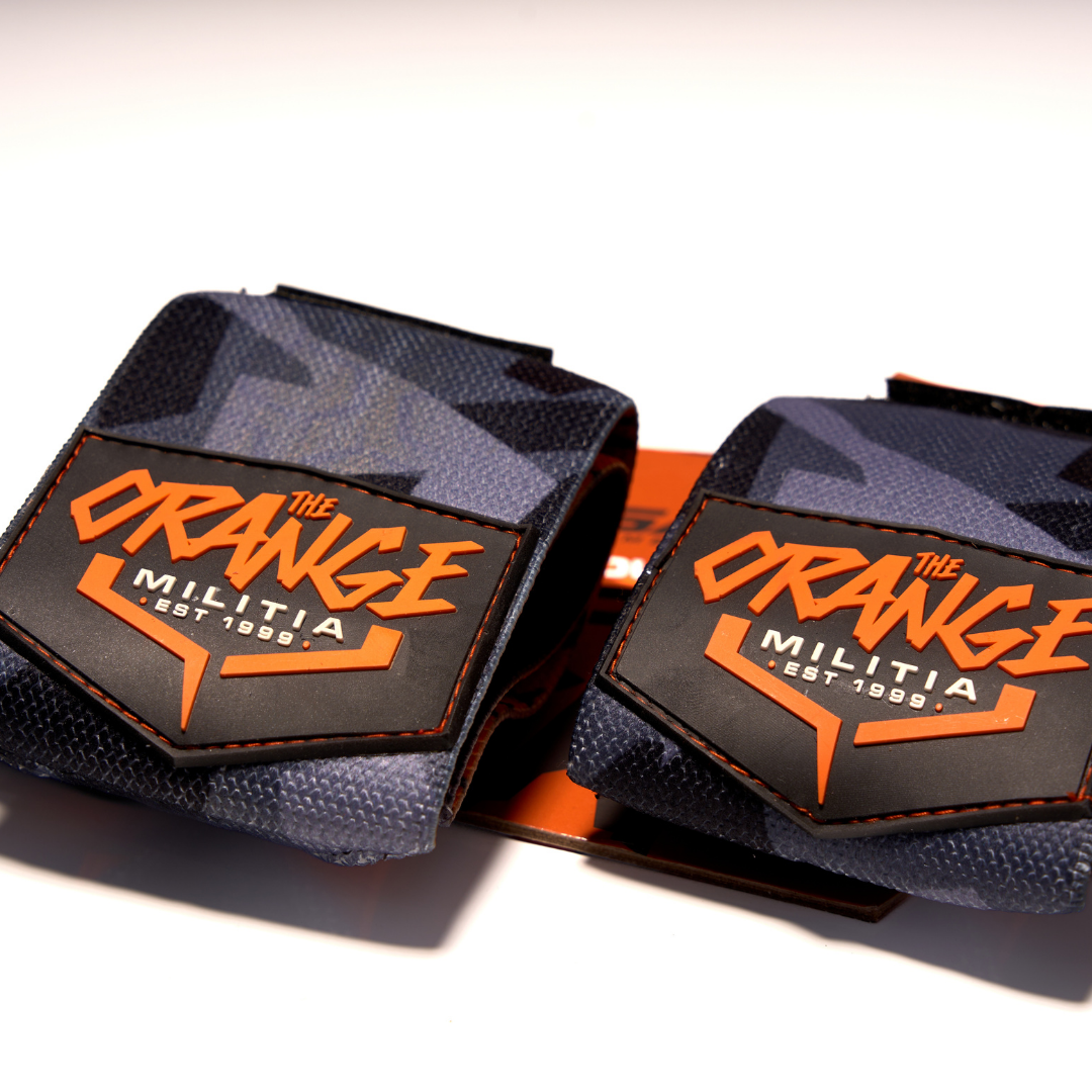 Two wrist wraps with a camouflage pattern and the brand name 'ORANGE MILITIA' printed on the strap.